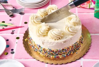 Knife being used to cut a round cake